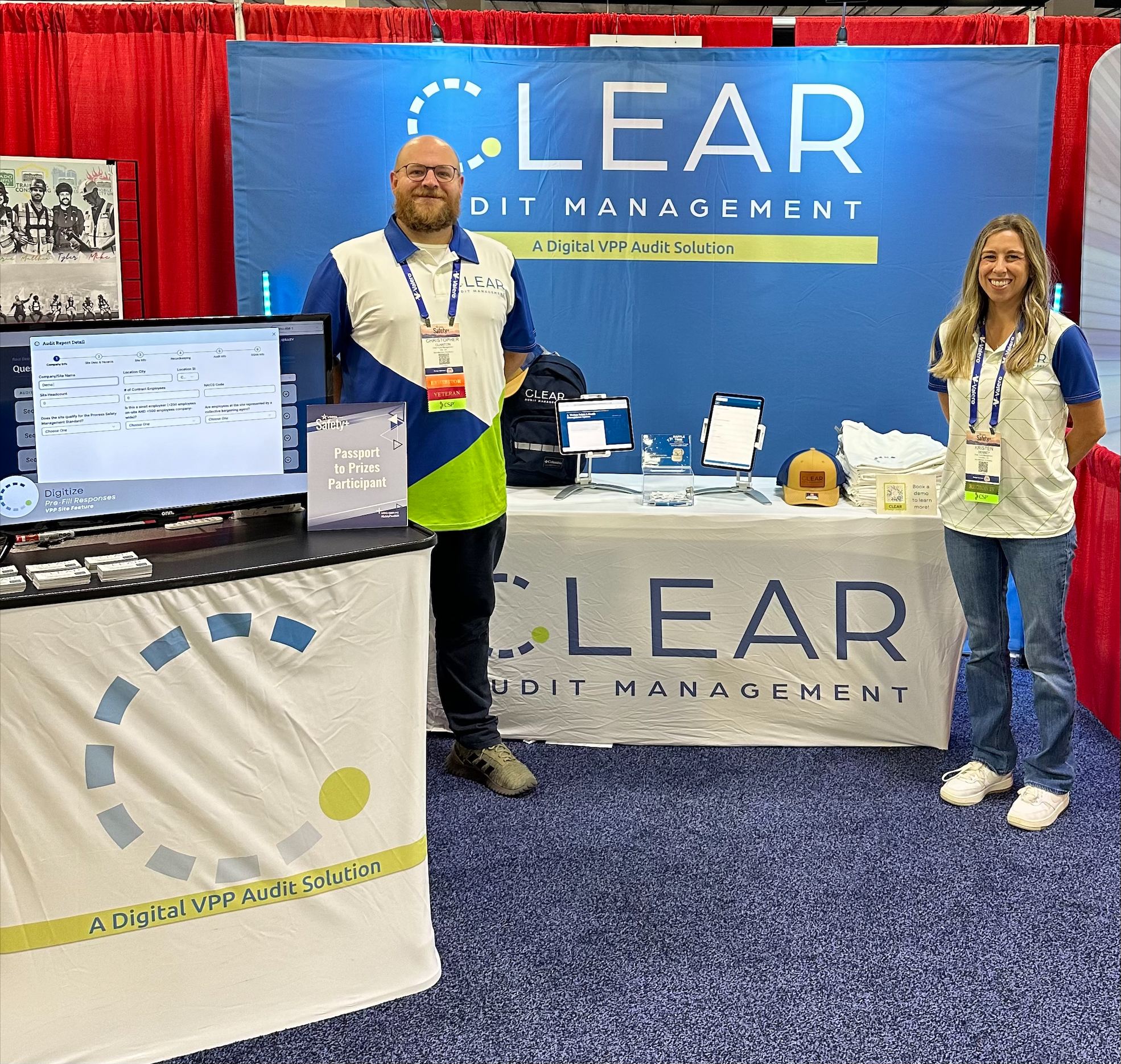 Christopher Clanton (left) standing with Kristen Denney (right) in front of the CLEAR audit management logo in their booth at the 2024 VPPPA conference.