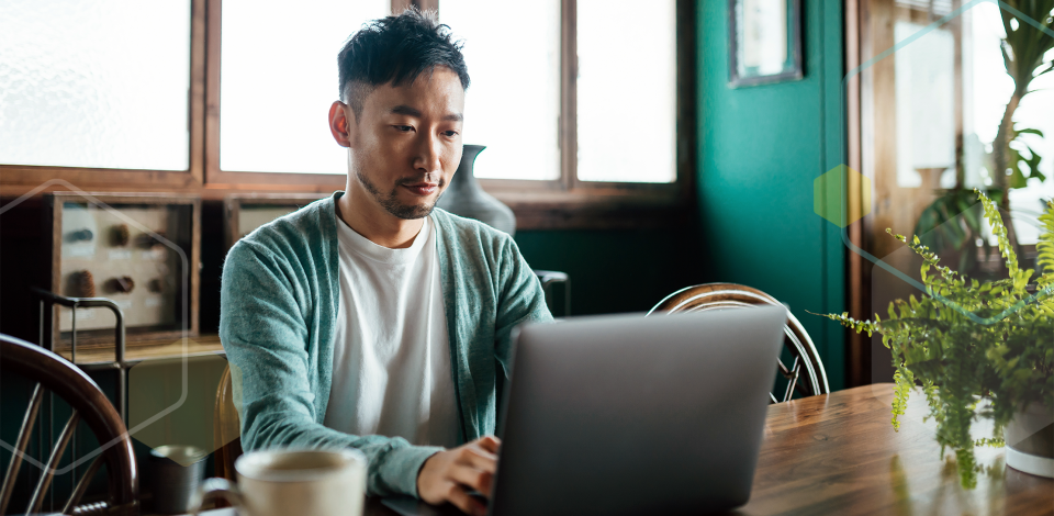 A man sitting at a table using a computer.