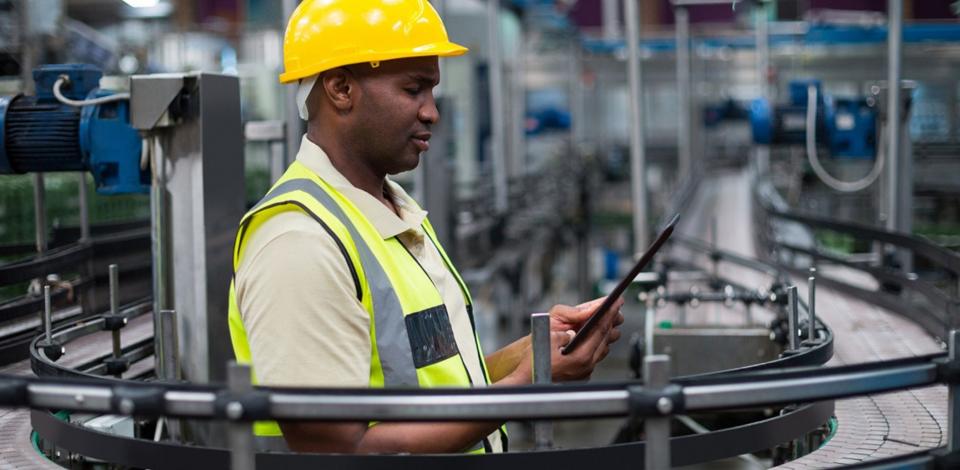 Manufacturing professional working on tablet in factory