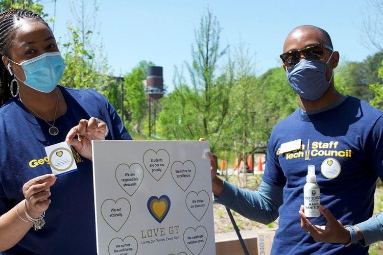 Georgia Tech employees handing out L.O.V.E. GT stickers