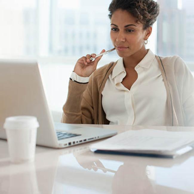 Female professional stares at laptop screen trying to find motivation